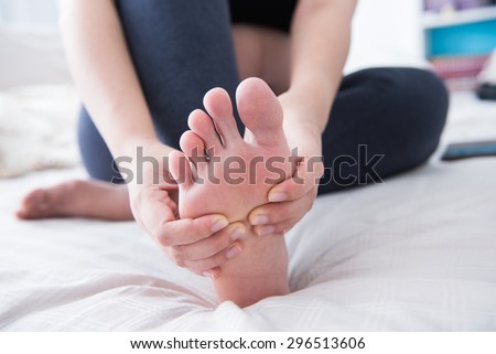 Closeup of pregnant woman hands doing foot massage 