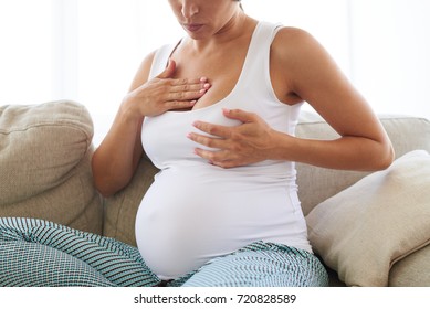 Closeup of pregnant woman having painful feelings in breast