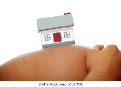 Close-up of pregnant woman touching her belly with toy house on it