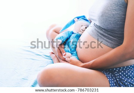 Pregnant woman embraced by her husband