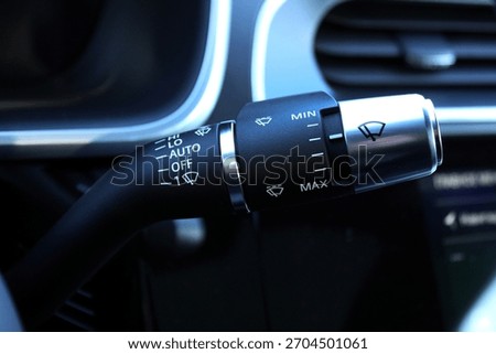Close-up premium windshield wiper control stalk in luxury vehicle interior. Black plastic car wiper control stalk. Car wiper switch. Wiper handle switch in car