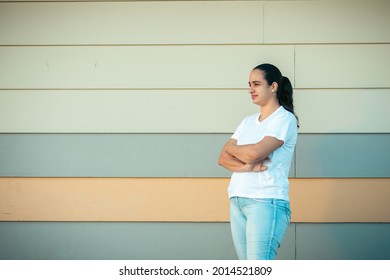 A Closeup Of A Pretty Young Hispanic Female Standing With Crossed Arms Waiting For Someone