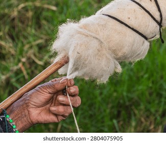 Close-up of process of hand spinning raw sheep wool into into yarn