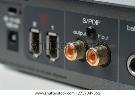 Close-up of professional audio interface rear panel featuring digital S-PDIF RCA connectors and FireWire ports for high-speed studio recording and music production connectivity on grey metal housing.