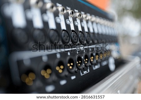 Close-up of professional audio patch panel with XLR and audio input connectors. Sound engineering, music production, broadcasting, recording studio, live event and audio technology concept