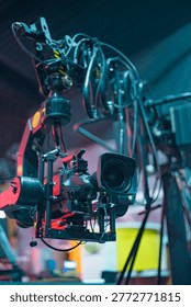 Close-up of professional broadcasting camera rig with tangled wires on a robotic jib arm in a modern tv studio environment