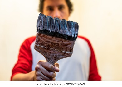 Close-up Of Professional House Painter Holding Dirty Paintbrush