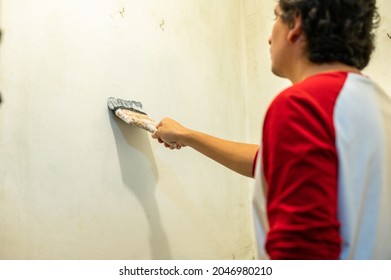 Close-up Of Professional House Painter Painting A White Wall