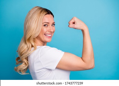 Closeup Profile Photo Of Attractive Lady Wavy Blond Hairdo Raise Arm Showing Big Shape Muscle Biceps Successful Sporty Person Wear Casual White S-shirt Isolated Blue Color Background