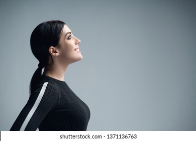 Closeup Profile Portrait Of Smiling Woman Looking Up At Blank Copy Space, Over Gray Background