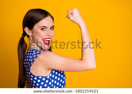 Close-up profile side view portrait of her she nice attractive pretty strong lucky successful cheerful cheery girl showing muscles yes win isolated bright vivid shine vibrant yellow color background