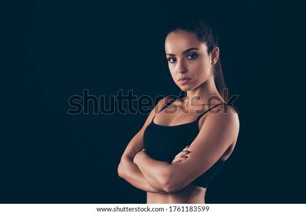 「黒い背景に美しいスポーツ的な強い筋肉質の女性が腕を組んだ身体的な運動エネルギーのライフスタイルを描いた、プロフィールの側面図の接写」の写真