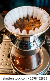 Close-up Of A Prover Standing On A Bar Counter In A Cafe. Ground Coffee Is Poured On Top Of The Pouver In The Filter And Water Is Spilled. Alternative Coffee Brewing Method