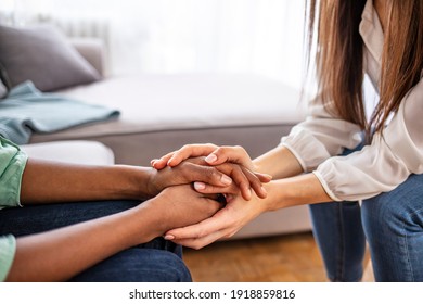 Close-up of psychiatrist hands together holding palm of her patient. Hands of woman reassuring her colleague. Diverse women. African american family couple holding hands - Shutterstock ID 1918859816