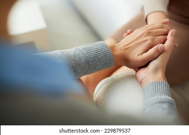 Close-up of psychiatrist hands together holding palm of her patient