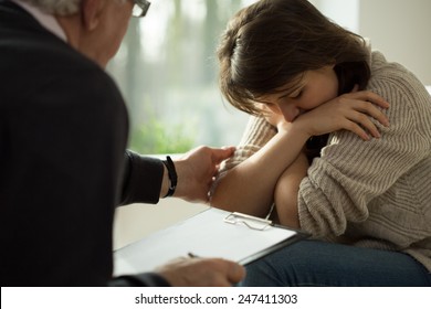 Close-up of psychologist comforting his depressed patient