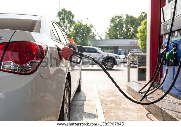 Closeup of 
pumping gasoline fuel in car at gas station. Petrol or gasoline
being pumped into a motor vehicle
car.