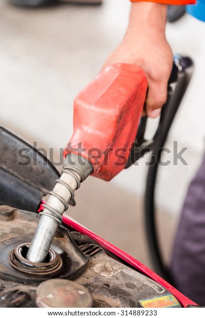 Closeup of\
pumping gasoline fuel into motorcycle\
tank