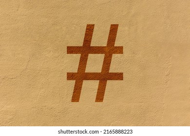 Close-up Of A Punctuation Mark Engraved On A Yellow Wall, In This Case The Symbol Is The Hash Or Hashtag