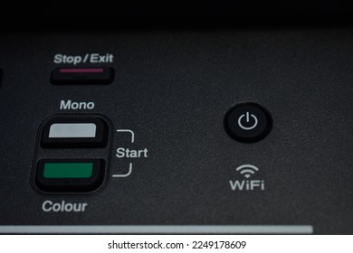 Close-up Push button panel on office printer modern with wifi wireless, power on off, scan, color and mono features, photographed on black background, office concept.