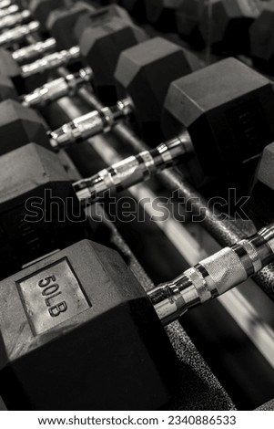 Closeup of a rack of hexagonal dumbbells at a gym or fitness club. Workout and training concept.