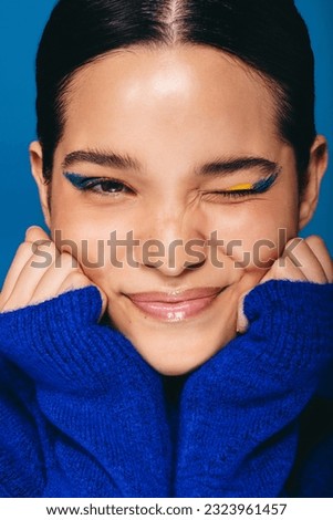 Closeup of a radiant young woman winking at the camera while wearing graphic eyeliner. Young woman feeling confident in her beauty radiating self-love and self-assurance.