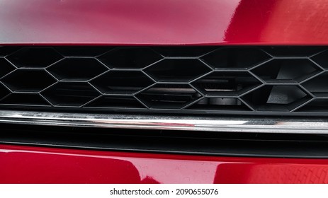 Close-up of the radiator grill of a red car. Details of cars