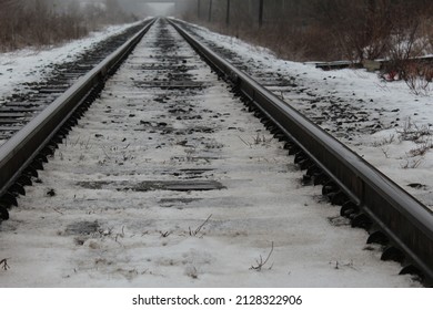 Closeup Of Railroad Tracks Covered In Ice And Snow From Ground Level In The Winter