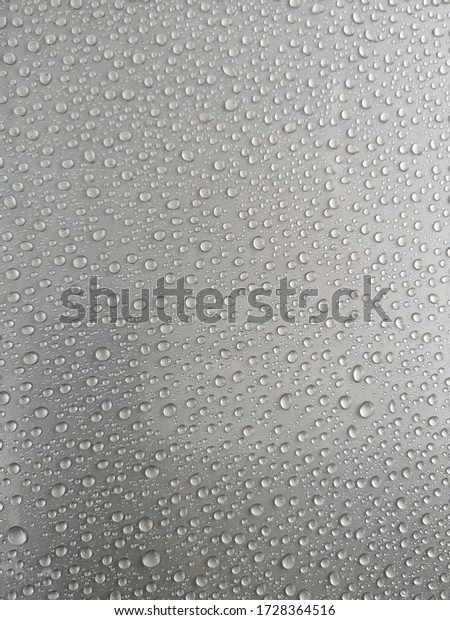 Closeup\
rain drops on silver car with hydrophobic\
coating