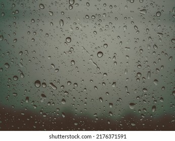 Closeup Raindrops On Glass Car In The Rainy Season.