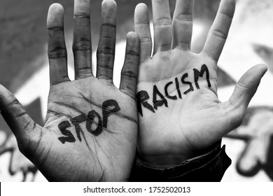 Close-up of the raised hands of two men of different ethnicity with the slogan 