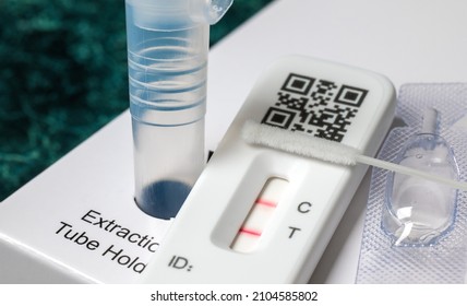 Close-up of rapid Covid-19 home lateral flow antigen test with positive result - Shutterstock ID 2104585802
