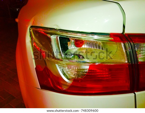 closeup of\
rare brake light of a white car at night\
