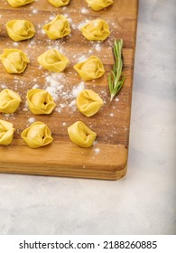 Close-up. Raw Dumplings, Ravioli On A Wooden Cutting Board Sprinkled With Flour.. Isolated On A White Background. Recipes For Home And Restaurant Cuisine. There Are No People In The Photo.