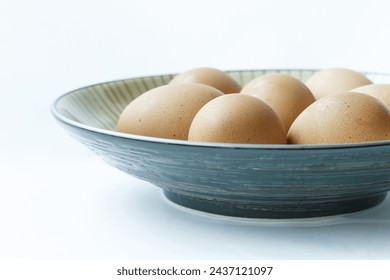 Close-up of raw eggs with light orange color on blue dish and white floor, South Korea
 Foto Stok