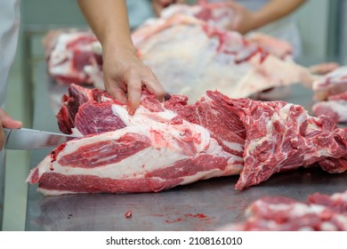 Close-up of raw meat cutting with a knife in an abattoir doing butchering and trimming of wagyu beef in the meat industry. Wagyu beef slices in beef cattle restaurants in many parts of Japan. - Powered by Shutterstock