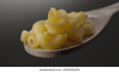 Close-up of Raw Pasta Shells on a Wooden Spoon - Powered by Shutterstock