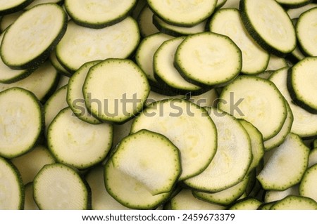 Close-up of raw zucchini slices on background