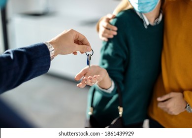 Close-up Of Real Estate Agent Giving House Key To A Couple. 