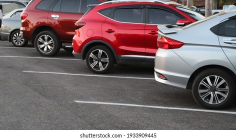 Closeup of rear, back side of blue car with  other cars parking in outdoor parking area in bright sunny day. - Shutterstock ID 1933909445