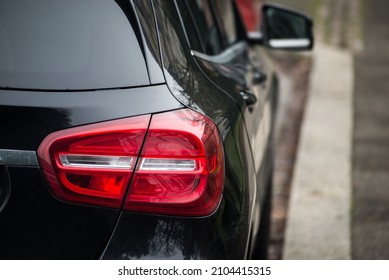 Closeup Of Rear Light Of Black Car Parked In The Street 