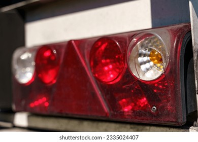 Close-up of the rear light of a truck semi-trailer with a damaged body. Road safety.