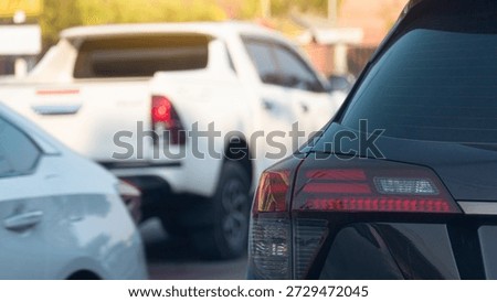 Close-up rear side of tail light of black car. Car driving queueing on the street. Cars were driving back and forth on the road.