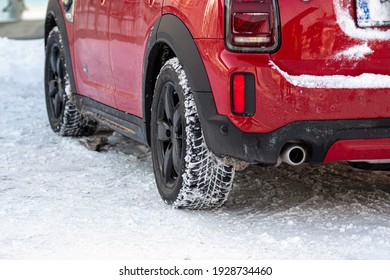 close-up rear view of a red car on parking,, dirty rear wheel tire on snow - Powered by Shutterstock