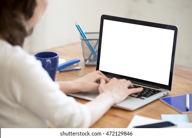 Close-up Rear View Of Young Business Woman Working In Office Interior On Pc On Desk, Typing, Looking At Screen. Office Person Using Laptop Computer, Sitting At Wooden Table In Small Office Workplace