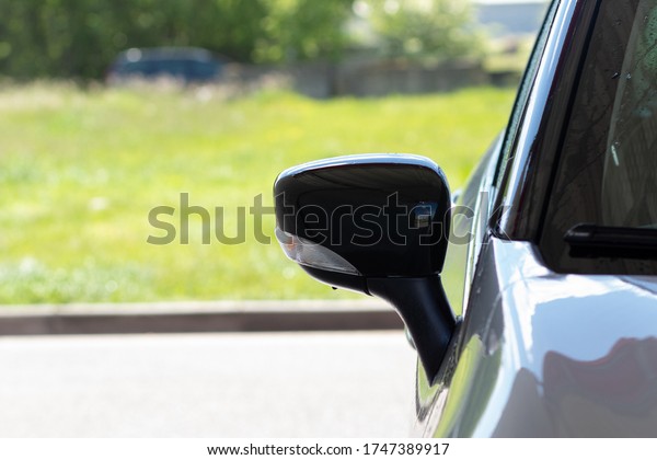 Close-up of the rearview mirror of\
a car with a turn signal repeater after washing with\
copyspace