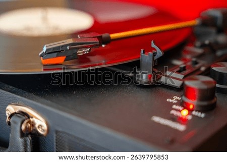 Close-up of record player needle tracking vinyl grooves during playback. Analog sound detail capturing retro music atmosphere. High quality photo