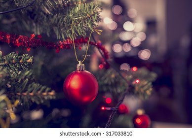 Closeup of red bauble hanging from a decorated Christmas tree. Retro filter effect. - Powered by Shutterstock