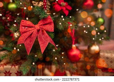 Close-up red bow on Christmas tree. Merry Christmas! Christmas background with lights and ornaments - Powered by Shutterstock