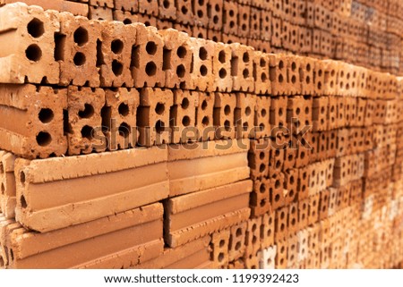 Closeup red brick stack wall, construction material concept